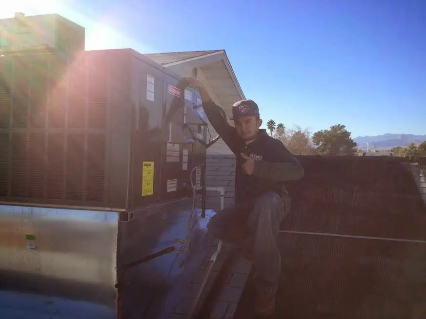 HVAC technician performing Boiler Repair on a rooftop unit in Pine Bluff